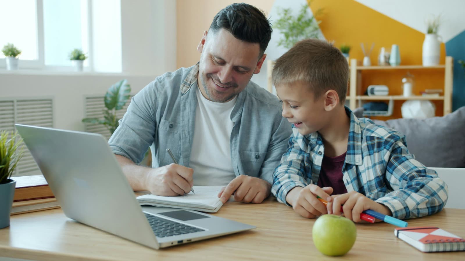 Lehrkraft erstellt gemeinsam mit einem Kind am Laptop einen Lernplan
